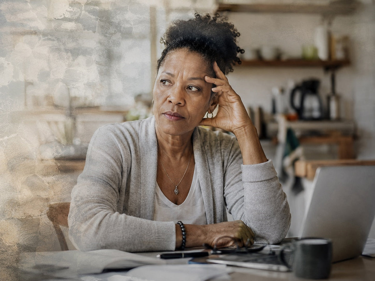 Midlife woman pausing mid-task at home, representing frightening episodes of menopause brain fog.