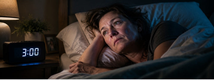 Midlife woman awake in bed during the night, representing repeated 3am waking and menopause sleep problems.